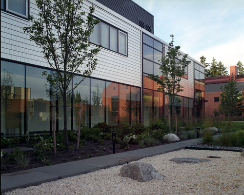 Rieke Science Center reflected in the windows of Morken Center for Learning and Technology at Pacific Lutheran University,  showing the stainless steel siding tiles.